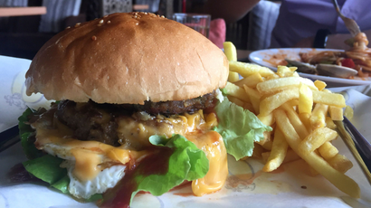 a giant cheesy hamburger with French fries