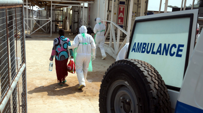 A health worker escorts a newly admitted Ebola patient in to the Kerry town Ebola treatment centre outside Freetown December 22, 2014.