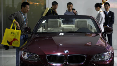 Visitors look at a BMW 320i convertible car at the Guangzhou Autoshow November 23, 2009. China's car makers hope Beijing will renew strong economic incentives that propelled China's car sales to record levels this year even in the face of the global downturn. REUTERS/Tyrone Siu