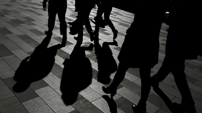 Workers cast shadows as they walk in Sydney