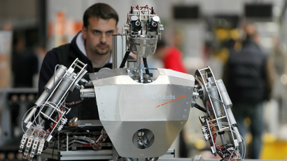 A worker sets up a robot during final preparations at the "Hannover Messe" industrial trade fair in Hanover