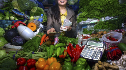 woman with vegetables and money