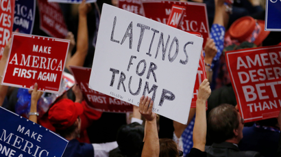 A person holds a sign reading 'Latinos for Trump'