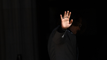 A single hand waving against a black background.