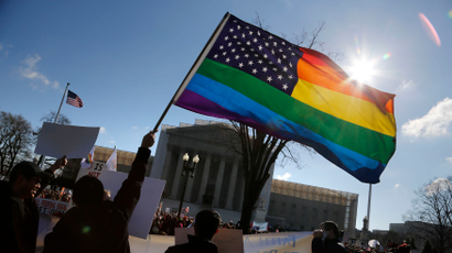 Anti-Proposition 8 protesters wave a rainbow flag in front of the U.S. Supreme Court in Washington, March 26, 2013. Two members of the U.S. Supreme Court, both viewed as potential swing votes on the right of gay couples to marry, raised doubts about California's gay marriage ban on Tuesday as they questioned a lawyer defending the ban. REUTERS/Jonathan Ernst (UNITED STATES - Tags: POLITICS SOCIETY CIVIL UNREST TPX IMAGES OF THE DAY) - RTXXY6A