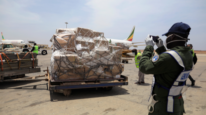 A gendarm takes photographs of a shipment of Covid-19 medical supplies donated by Jack Ma and the Alibaba Foundation, after it arrived in Senegal from Ethiopia, March 2020.