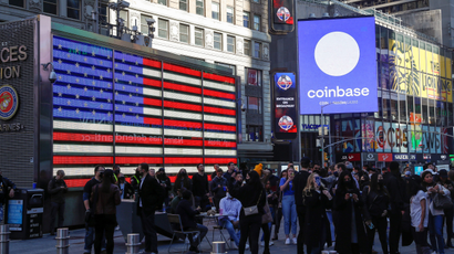Employees of Coinbase Global Inc, the biggest US cryptocurrency exchange, watch as their listing is displayed on the Nasdaq MarketSite jumbotron at Times Square in New York, U.S., April 14, 2021.