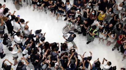 A man holds up a tuba as protesters shout slogans and sing Hong Kong's anthem during a protest at New Town Plaza shopping mall in Hong Kong, China September 11, 2019.