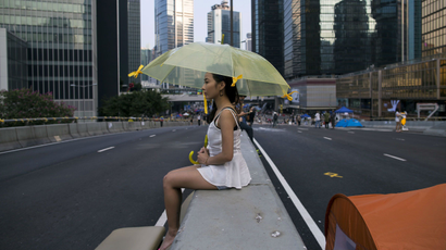 protester of the Occupy Central movement, sits on a divider used by demonstrators to block the main road leading to the financial Central district in Hong Kong October 9, 2014