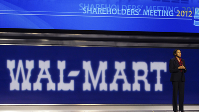 Sam's Club CEO Rosalind Brewer stands in front of a large, dark blue Wal-Mart sign during the company's annual shareholders' meeting.