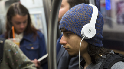 A commuter listens to Beats brand headphones while riding subway in New York