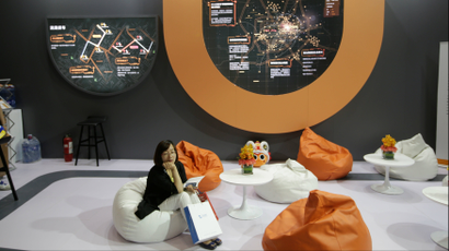 A woman sits at Didi Chuxing's booth at the Global Mobile Internet Conference (GMIC) 2017 in Beijing, China