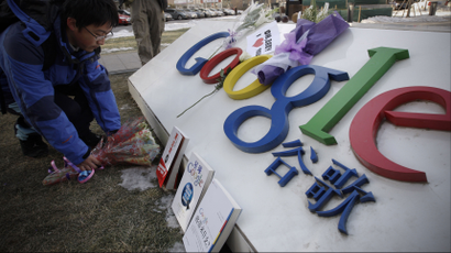 A Chinese Google user presents flowers in front of Google sign outside Google China headquarters building in Beijing, Friday, Jan. 15, 2010. China tried Friday to keep its censorship row with Google from damaging business confidence or ties with Washington, promising good conditions for foreign investors but giving no sign it might relax Internet controls.
