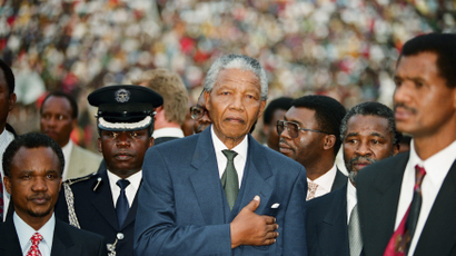 The newly sworn in first black President of South Africa Nelson Mandela keeps his hand on his hart as he listens to the national anthem near the Union building in Pretoria, May 10, 1994.