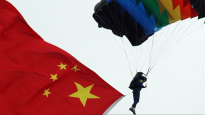 A soldier carrying a Chinese national flag parachutes over a stadium in Wuhu, east China's Anhui province.