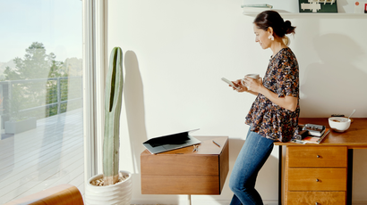 A woman uses her phone in a sunlit home with Southwest decor