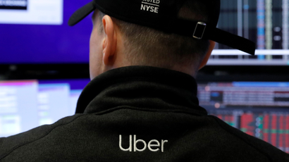 A trader on the NYSE wearing an Uber hat and fleece