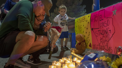 Rene Aguilar and Jackie Flores pray at a makeshift memorial for the victims of Saturday's mass shooting at a shopping complex in El Paso, Texas, Sunday, Aug. 4, 2019.