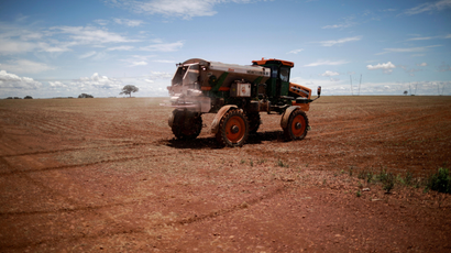 Tractor spreading fertilizer on a soybean field.