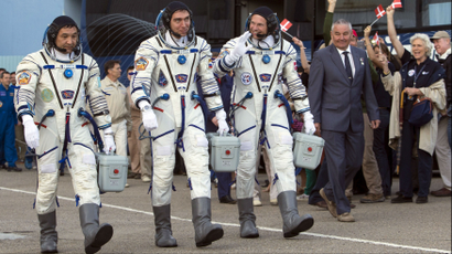 Three astronauts from Kazakstan walk in their spacesuits in Denmark.