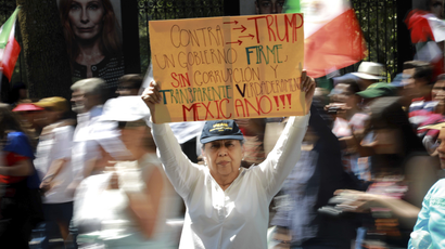 A woman holds up a banner that reads in Spanish: "Against Trump" in Mexico City march