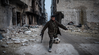 A Syrian rebel plays football in the Saif al-Dawlah neighborhood of Aleppo, Syria, Wednesday, Jan. 2, 2013. The United Nations estimated Wednesday that more than 60,000 people have been killed in Syria's 21-month-old uprising against authoritarian rule, a toll one-third higher than what anti-regime activists had counted. The U.N. human rights chief called the toll "truly shocking." (AP Photo/Andoni Lubacki)