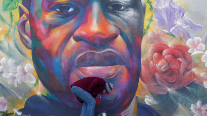 A man places flowers at a mural of George Floyd after the verdict in the trial of former Minneapolis police officer Derek Chauvin, found guilty of the death of Floyd, in Denver, Colorado, U.S., April 20, 2021.