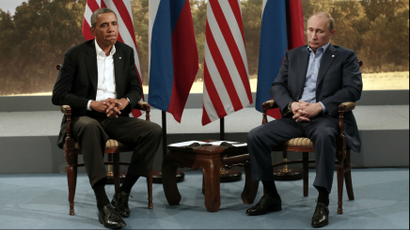 President Obama and President Putin sit in front of two American flags and two Russian flags.