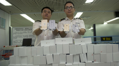 Customs officers pose for photographs as they display smuggled iPhone 6 sets, which were seized at the customs of a port in Shenzhen, near the Hong Kong border in Guangdong province
