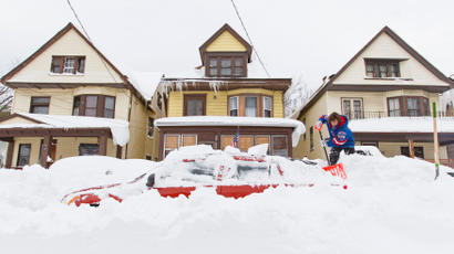 Lori Weishaar shovels snow from around her vehicle following an autumn snow storm in Buffalo, New York, November 20, 2014. Snowbound residents of western New York awoke to as much as another foot of accumulation on Thursday with possibly another 30 inches expected, according to meteorologists. REUTERS/Aaron Lynett (UNITED STATES - Tags: ENVIRONMENT TPX IMAGES OF THE DAY) - RTR4EXDU
