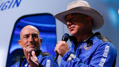 Jeff Bezos speaks as his brother Mark looks on during a post-launch press conference after they flew on Blue Origin's inaugural flight to the edge of space.