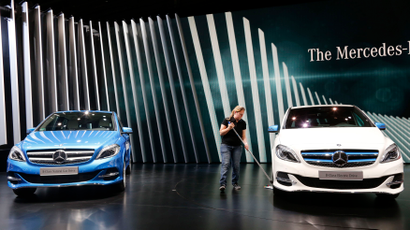 A woman cleans near Mercedes-Benz cars before a news conference on media day at the Paris Mondial de l'Automobile, October 2, 2014. The Paris auto show opens its doors to the public from October 4 to October 19.