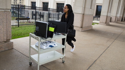 An employee at the Indiana Department of Revenue moves her computer equipment from her office on March 24 to allow her to work from home.