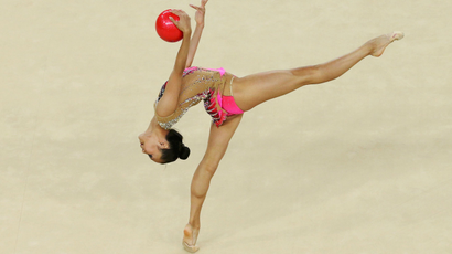 Rhythmic gymnast performs with ball.