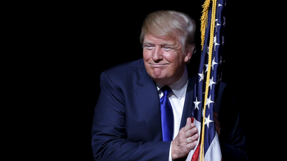 Donald Trump grinning with a flag