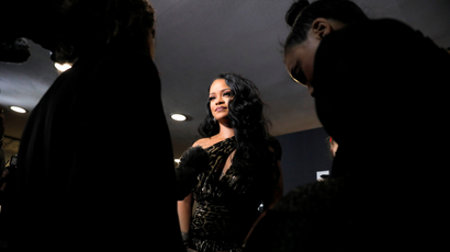 Rihanna, dressed in black, in the middle of a few people