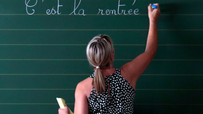 A teacher writes on a board
