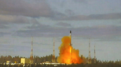 A missile is seen launching from a launch pad, with clouds of smoke and fire around it.