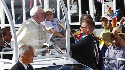 Pope Francis kisses a child as he arrives to lead a mass for Catholic faithful in the city of Holguin