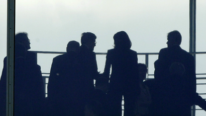 Figures of people are silhouetted in an office