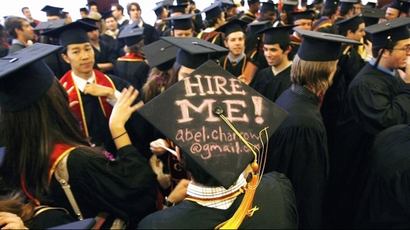 graduates with hire me sign