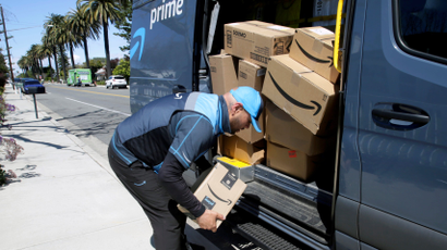 An Amazon delivery man unloads packages from a van.