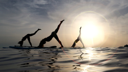 People practice standup paddleboard yoga, or SUP yoga, on the Adriatic coast in Verudela, Croatia July 10, 2017.