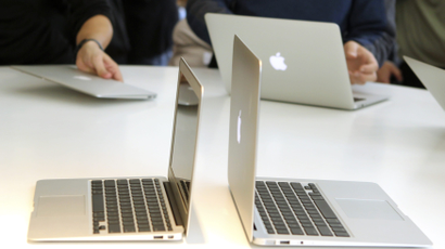 Several open Mac AirBook laptops sit on a table.