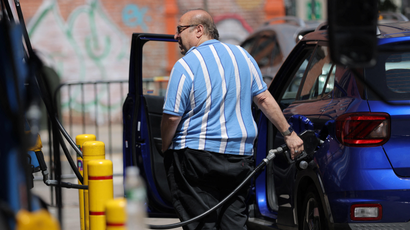 A person puts gas in a vehicle at a gas station in Manhattan, New York City.