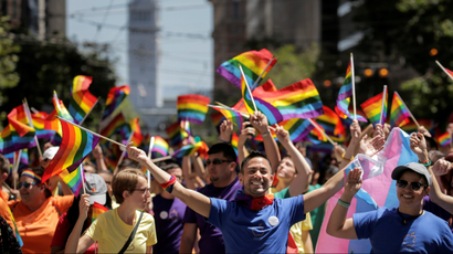 Apple employees wave rainbow flags while marching in the San Francisco LGBT Pride Parade in San Francisco, California