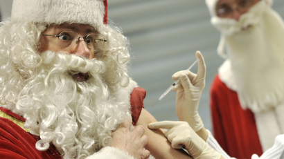 a man dressed as santa gets a flu shot
