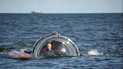 Russia's President Vladimir Putin (L) is seen through the glass of C-Explorer 5 submersible after a dive to see the remains of the naval frigate "Oleg", which sank in the 19th century, in the Gulf of Finland in the Baltic Sea July 15, 2013.