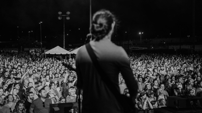 Photo taken from behind Adam Met of AJR on stage, looking out into the audience, at the Basilica Block Party Festival in Minneapolis, September 2021.