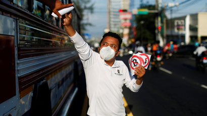 A man gives away stickers as part of a campaign against the use of Bitcoin as legal tender in San Salvador, El Salvador.